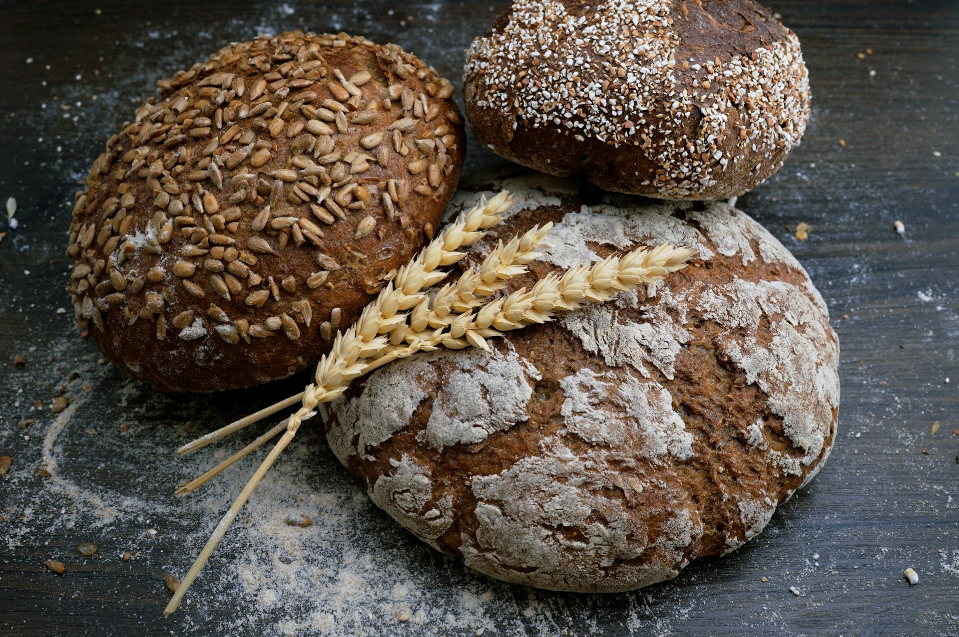 Rustic display of freshly baked golden brown sourdough bread and pastries on a wooden shelf, bakery ambiance